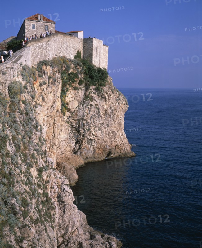 CROATIA, Dalmatia, Dubrovnik, Tourists climbing the city walls atop a rocky cliff overlooking the Adriatic sea