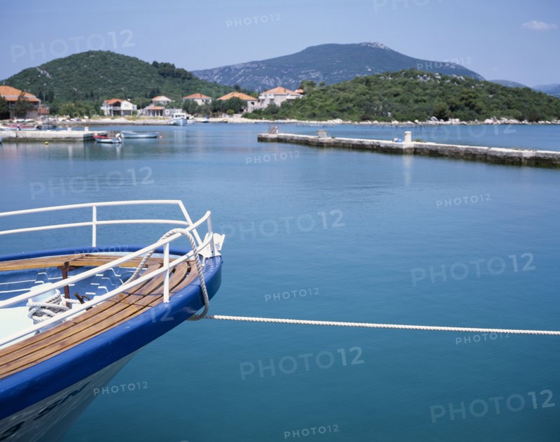 CROATIA, Dalmatia, Ston, Prow of a moored boat with coastline beyond