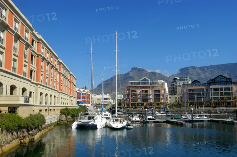 SOUTH AFRICA, Western Cape, Cape Town, View of the waterfront with moored boats and buildings against a backdrop of mountains