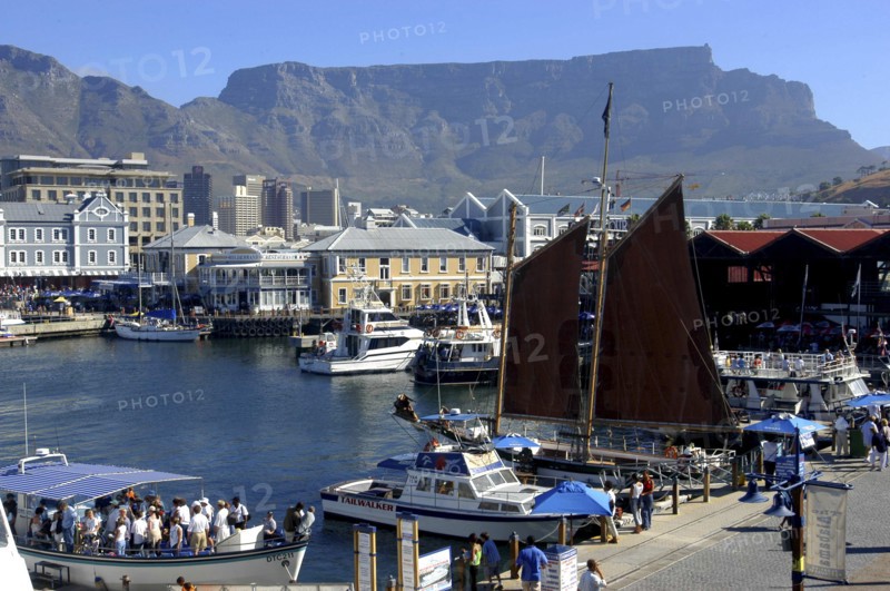 SOUTH AFRICA, Western Cape, Cape Town, View over the waterfront area with busy tourist boats and Table Mountain in the background