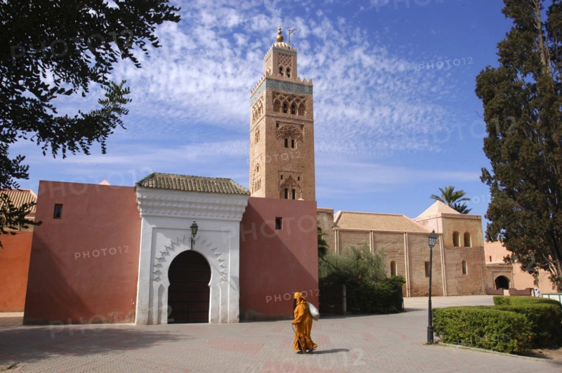 MOROCCO, Marrakech, Koutoubia Mosque with entrance gate and tower and passing woman