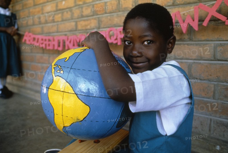 MALAWI, Blantyre, Schoolgirl with papier mache globe teaching aid made by PAMET who recycle everything from newspapers to elephant dung
