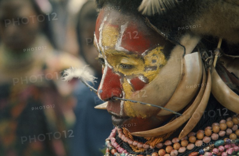 PAPUA NEW GUINEA, Portraits, Men, Tribesman with painted face and pierced nose.