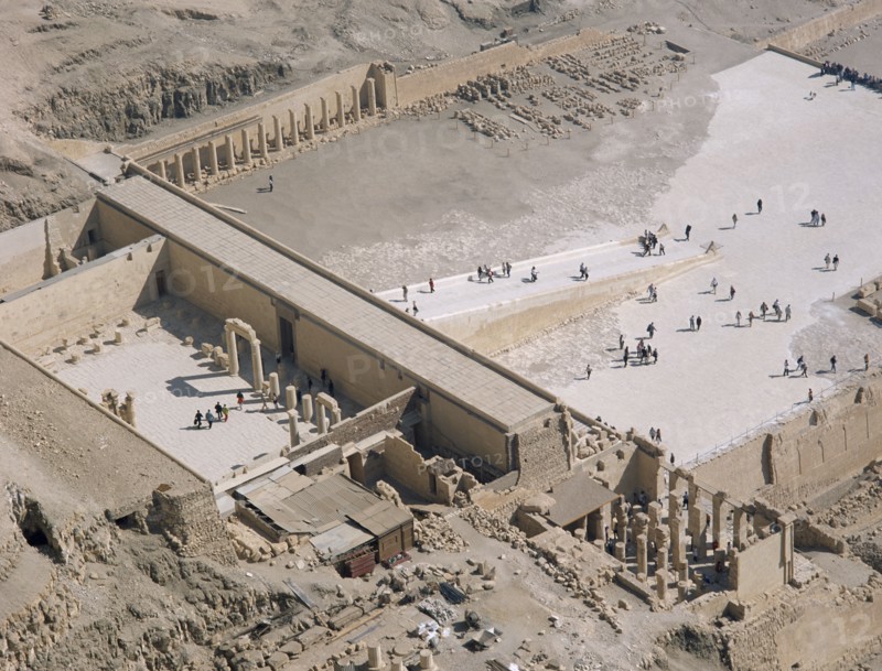 EGYPT, Nile Valley, Thebes, Hatshepsut Mortuary Temple. Deir el-Bahri. Elevated view from limestone cliffs over the temple with visitors walking towards ramped entrance