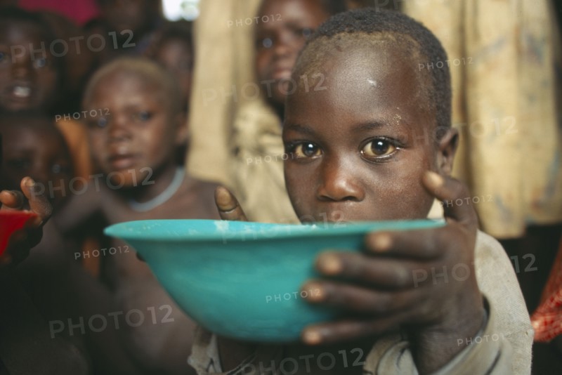 UGANDA, Moroto, Karamoja.  Feeding project for vulnerable people.  Child receiving bowl.