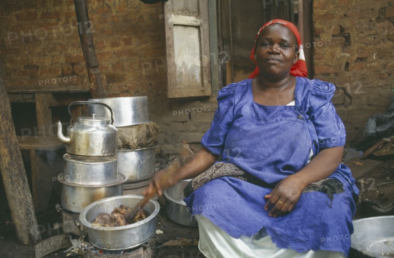 UGANDA, Kampala, Woman cooking for large household.