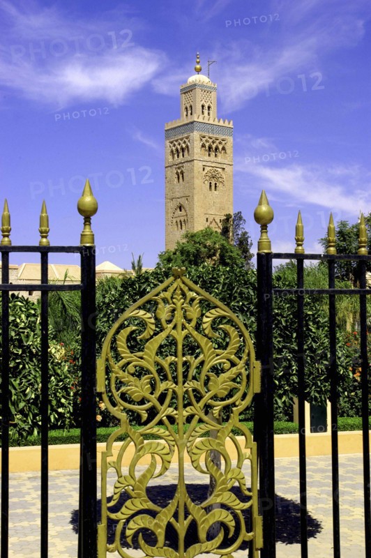 MOROCCO, Marrakech, View through black and gold wrought iron gate towards the minaret of Koutoubia Mosque
