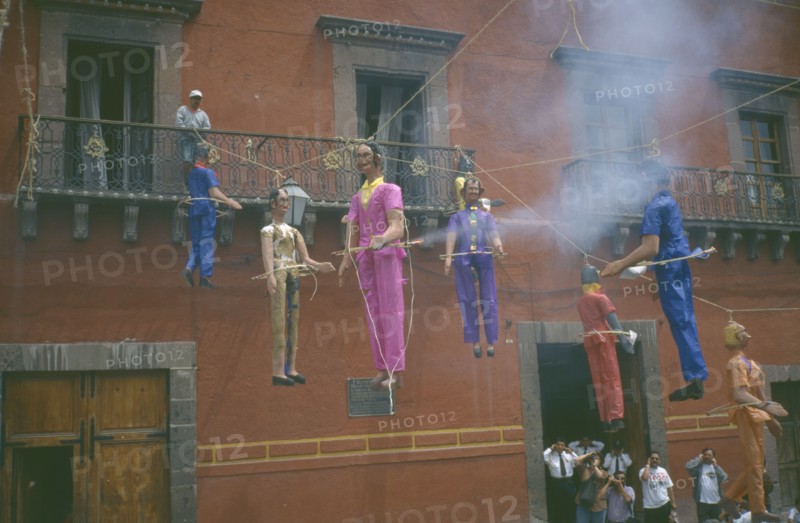 MEXICO, Guanajuato, San Miguel de Allende, Exploding papier mache figures of Judas hanging from balconies in Plaza Principal during Easter celebrations.