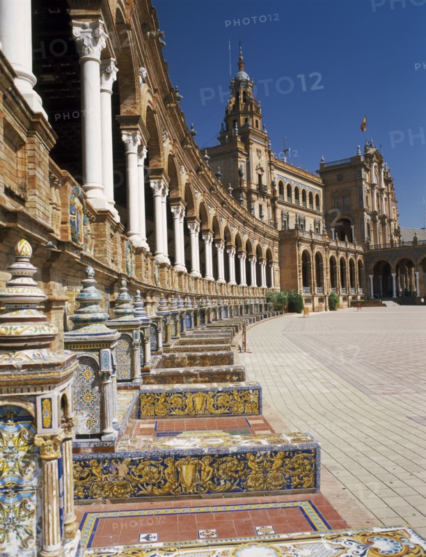 SPAIN, Andalucia, Seville, Plaza de Espana. View along colonnade and seats toward the Central Pavilion