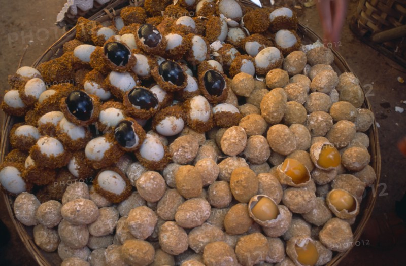 CHINA, Yunnan, Kunming, Covered food market  with baskets filled with thousand year old eggs.