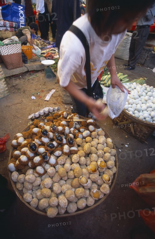 CHINA, Yunnan, Kunming, Covered food market  with baskets filled with thousand year old eggs.