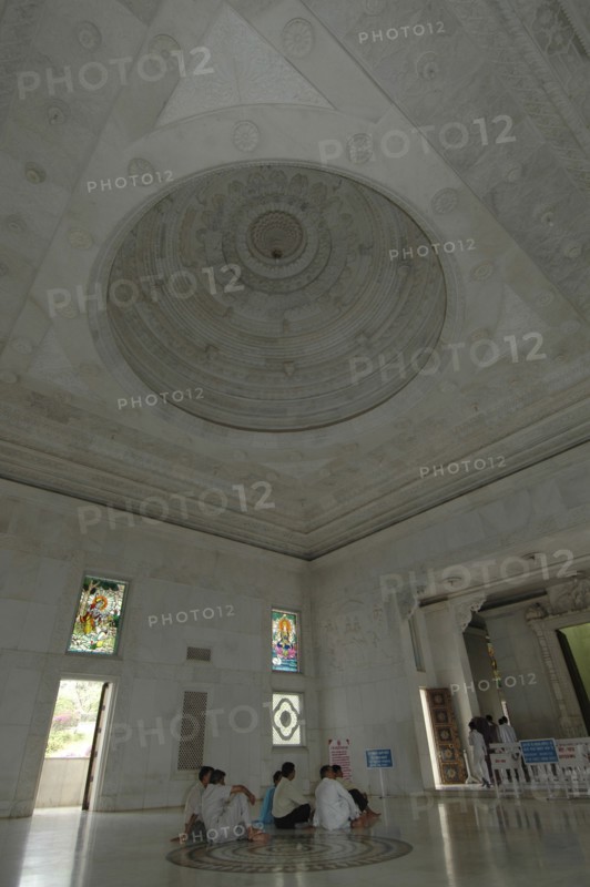 INDIA, Rajasthan, Jaipur, Interior view of Laxmi Narayan Temple with devotees sitting on the floor under the beautifully decorated marble domed ceiling
