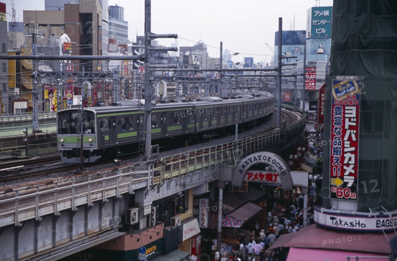 JAPAN, Honshu, Tokyo, Train travelling along the elevated tracks above the Ameyayokocho market street