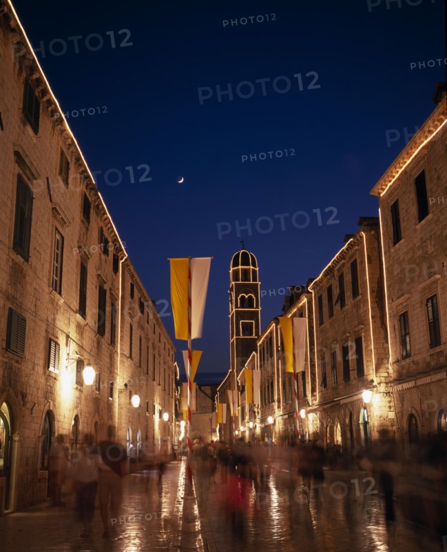 CROATIA, Dalmatia, Dubrovnik, View along the Stradun toward the Franciscan Monastery illuminated at night