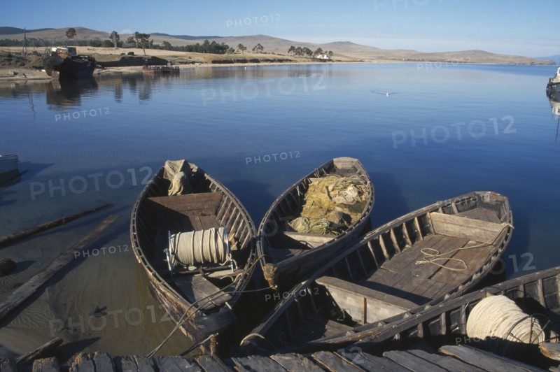RUSSIA, Siberia, Lake Baikal, Wooden fishing boats moored beside wooden jetty.