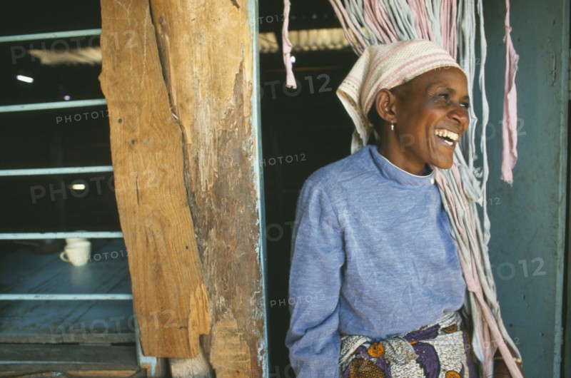 TANZANIA, Kisongo, Arusha, "Kisongo Masai market outside Arusha.  Portrait of Pauline, owner of small teahouse, laughing in doorway."
