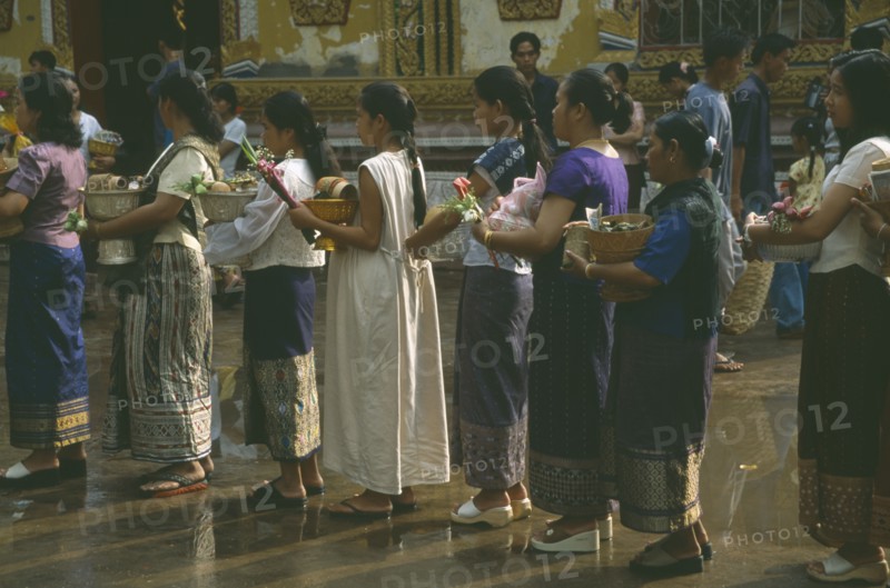 LAOS, Vientiane, Line of young women with offerings for the Awk Phansaa festival.