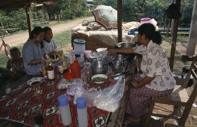 LAOS, Vientiane, Two girls eating at Mrs Tongs roadside noodle stall