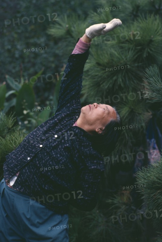CHINA, Shanghai, Elderly woman doing Tai Chi exercises