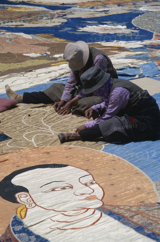 CHINA, Tibet, Lhasa, Potola Palace.  Workers sewing huge Buddha Tankha spread out on floor.