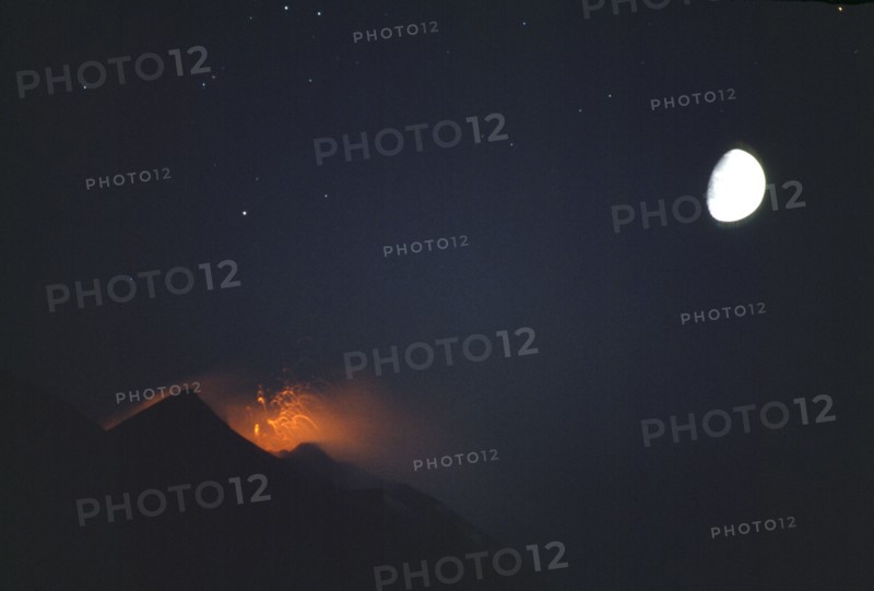 ITALY, Aeolian Islands, Stromboli, Night view of the active volcano hourly eruption with moon behind