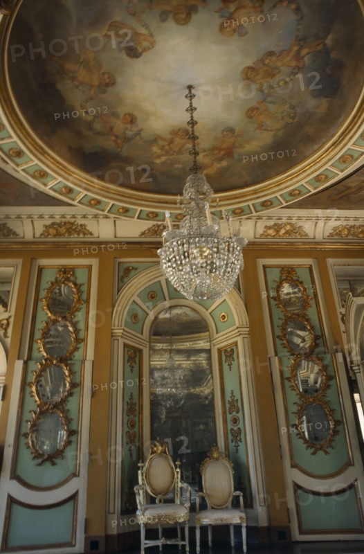 PORTUGAL, Near Lisbon, Palacio Nacional de Queluz interior. Sala dos Exbaixadores with throne chairs and detail of hanging chandelier and ceiling frescos.