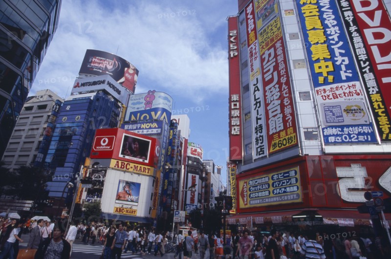 JAPAN, Honshu, Tokyo, Shinjuku. View of advertisement covered architecture in busy city street scene
