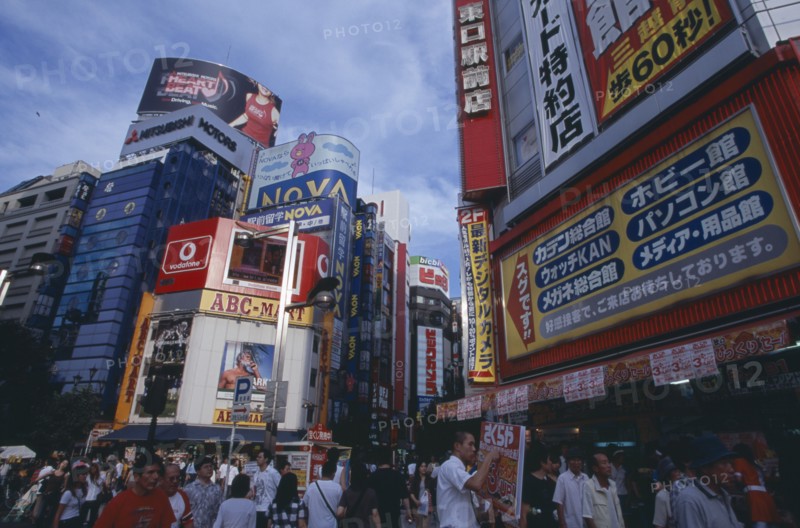 JAPAN, Honshu, Tokyo, Shinjuku. View of advertisement covered architecture in busy city street scene
