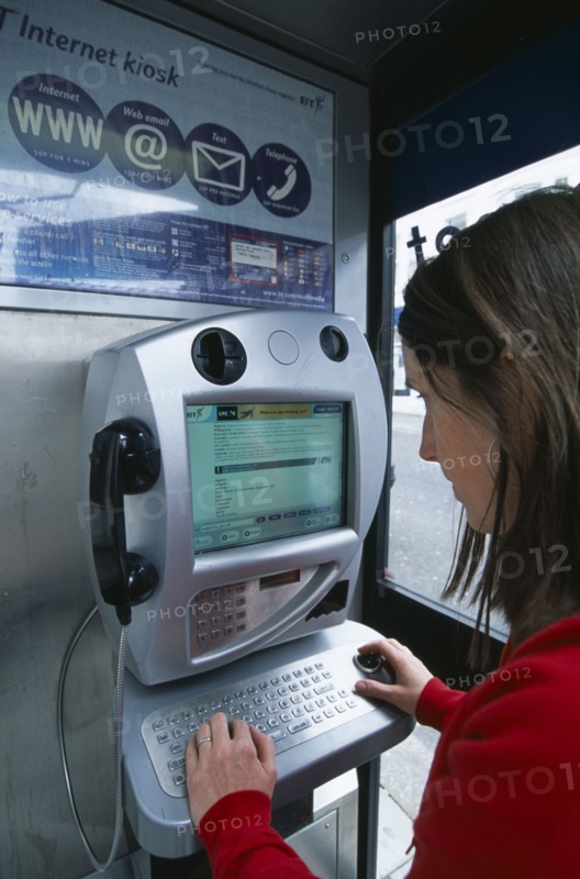 COMMUNICATIONS, Phone Box, Young woman using a public BT Internet phone booth.