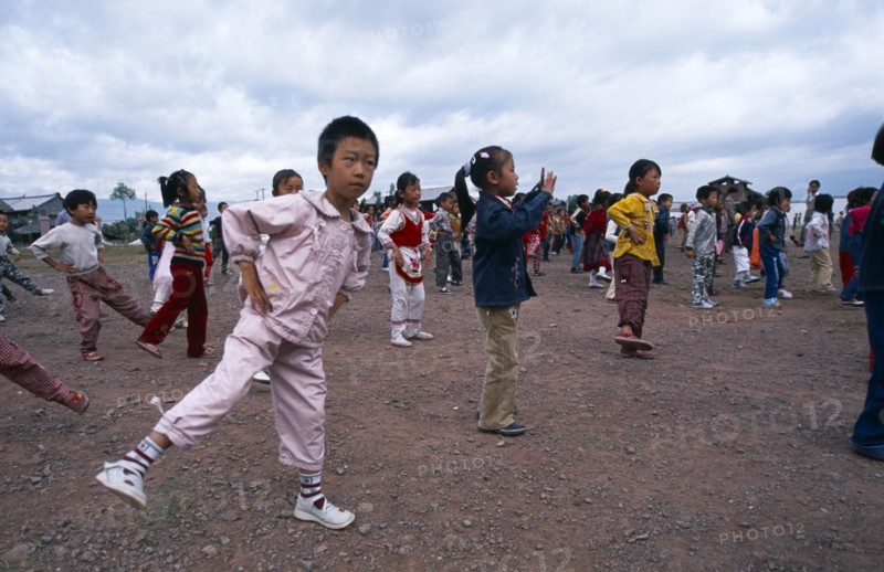 CHINA, Yunnan Province, Children taking in part in formation exercising outside of their school.