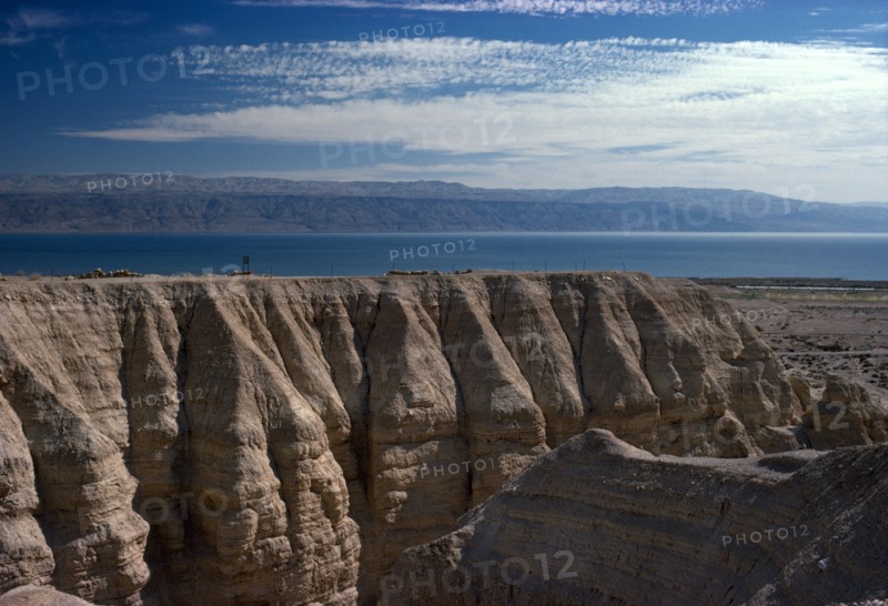 ISRAEL, Quamran, View over rocky eroded cliffs to the Dead Sea beyond