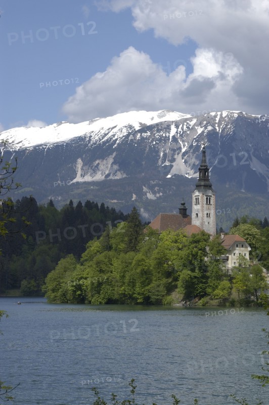 SLOVENIA, Lake Bled, View over the lake toward Bled Island and the Church of the Assumption with the snow capped peaks of the Julian Alps behind