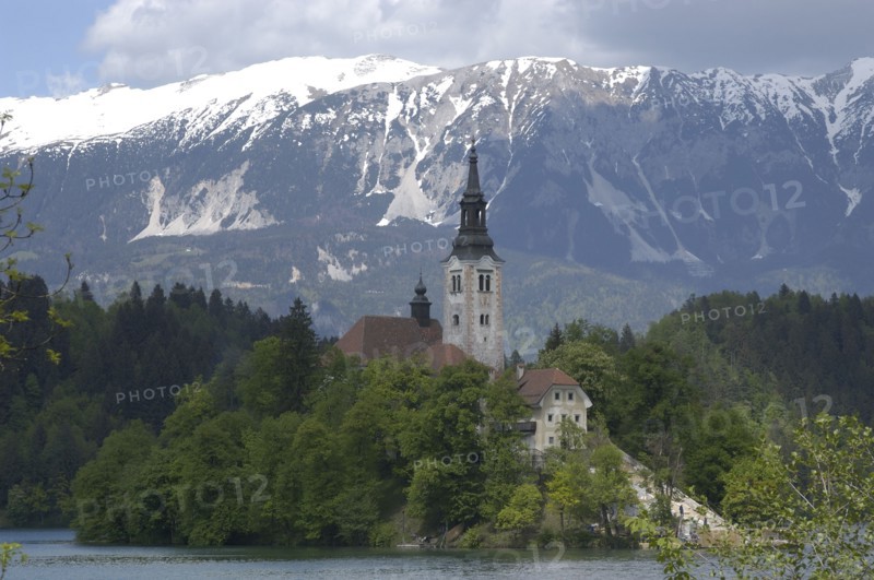 SLOVENIA, Lake Bled, View over the lake toward Bled Island and the Church of the Assumption with the snow capped peaks of the Julian Alps behind