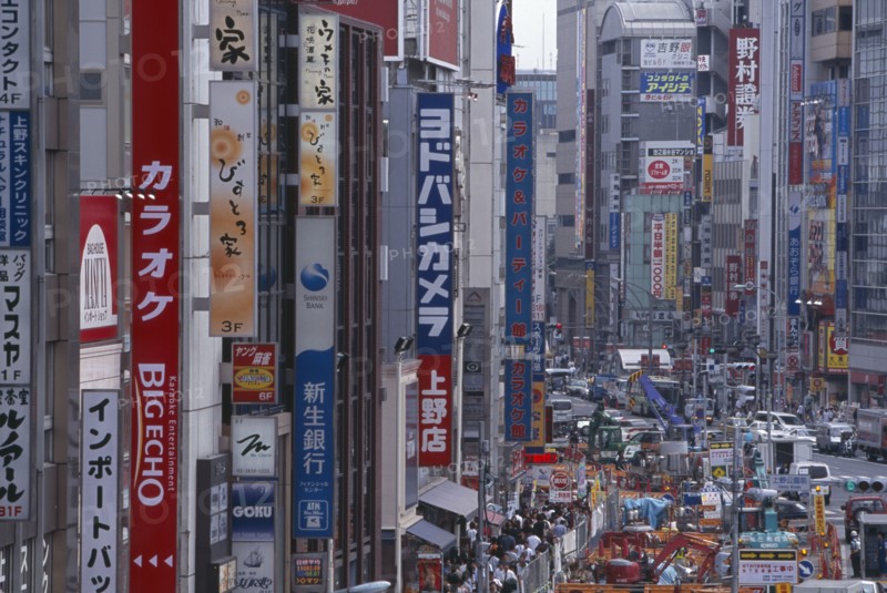 JAPAN, Honshu, Tokyo, Okachimachi. View along advertising signs covering the architecture of a busy city street