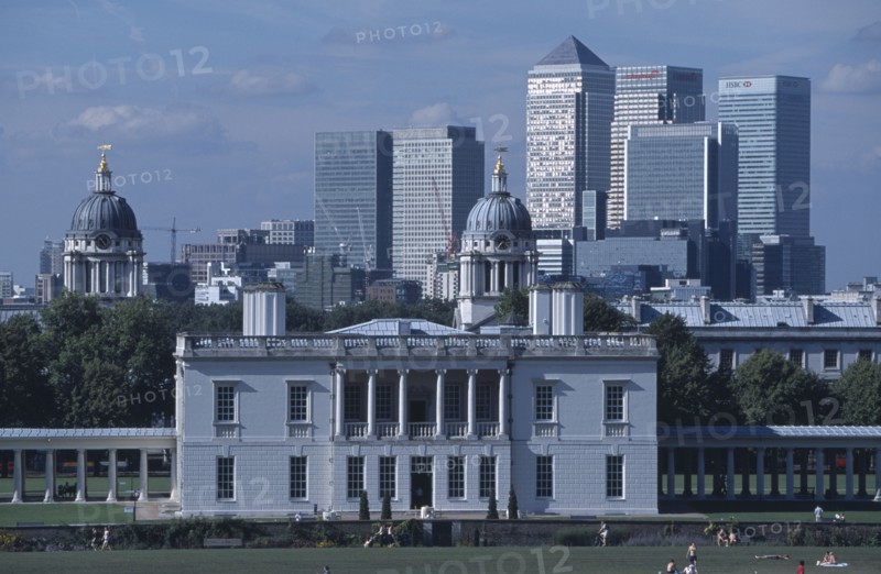 ENGLAND, London, Greenwich. View over lawn toward Queens House with the Canary Wharf skyline beyond