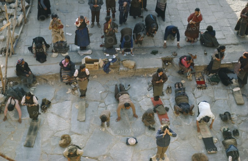 TIBET, Lhasa, Jokhang Monastery, Pilgrims prostrate themselves and pray in front of Jokhang Monastery.