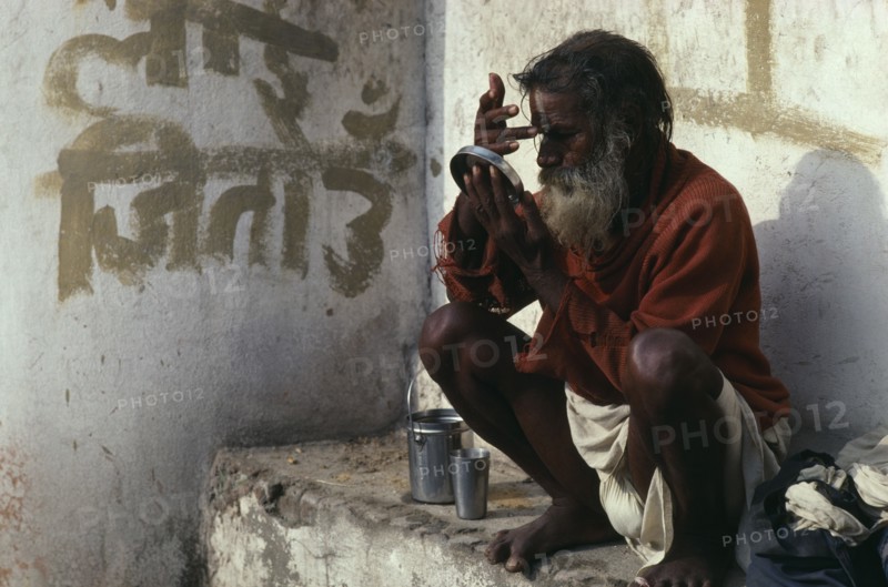 NEPAL, Kathmandu, Saddhu applying his tika mark of blessing at the Pashupatinath Temple Maha Shivaratri festival celebrating the birth of Shiva.