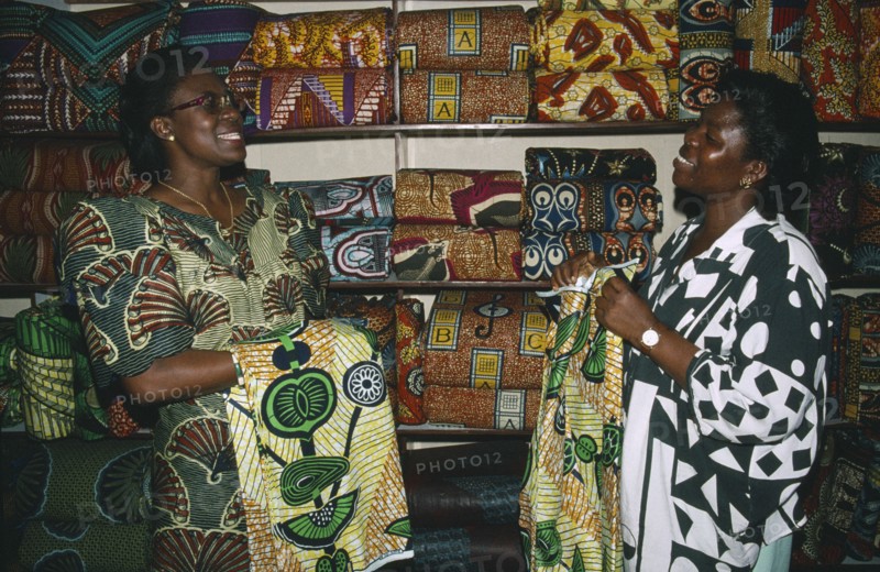 TOGO, Lome, Female cloth vendors selling traditional cloth at market.