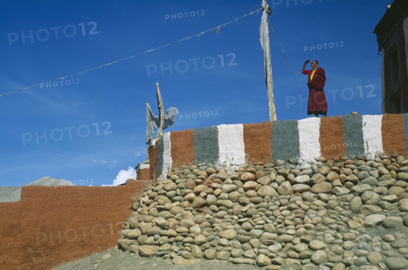 NEPAL, Mustang, Monk standing on painted terrace of Tsarang’s temple.