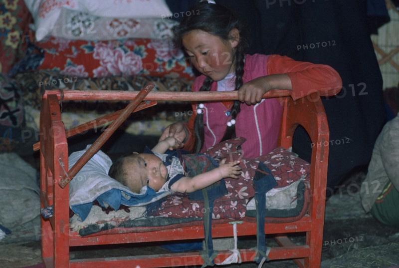 CHINA, Xinjiang Province, Altai Mountains, Kazakh siblings inside kigizuy.