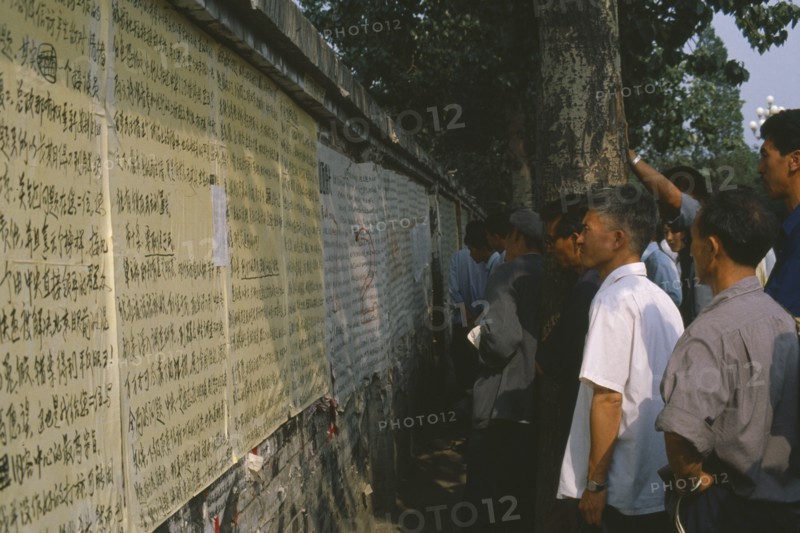 CHINA, Hebei, Beijing, Men reading posters on democracy wall.