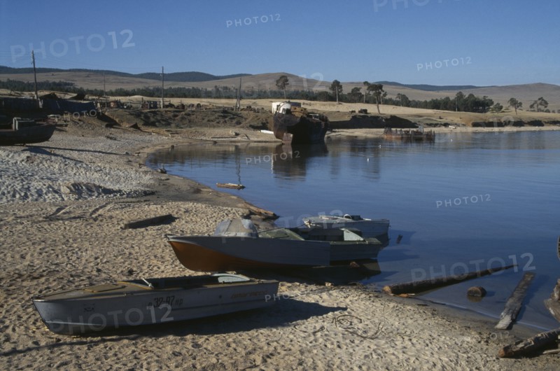 RUSSIA, Siberia, Lake Baikal, Fishing boats pulled up on lake shore.