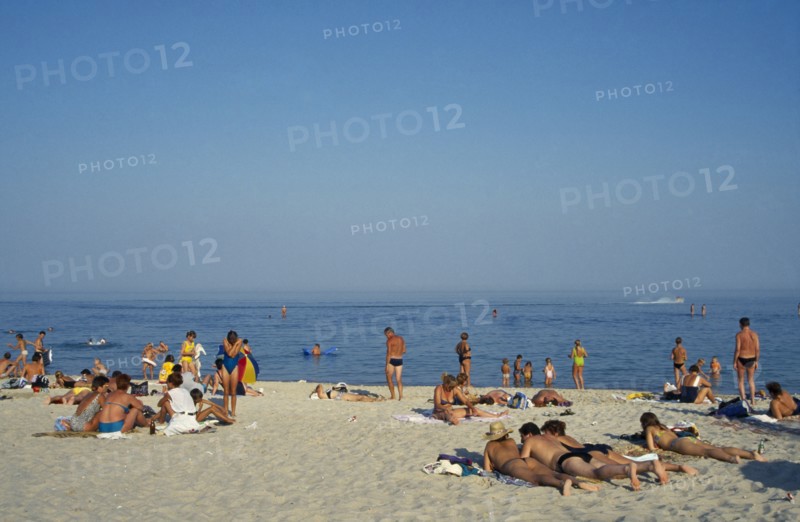 UKRAINE, Odessa, People sunbathing on sandy beach beside the Black Sea.