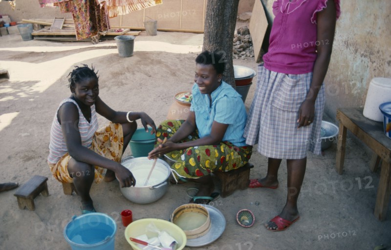 BURKINA FASO, Ouagadougou, Girls stirring milk.