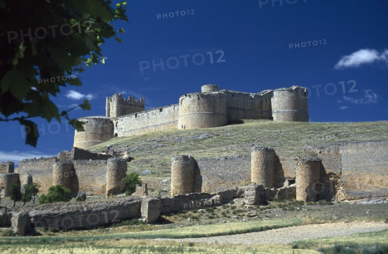 SPAIN, Castilla-Leon, Soria, Ruined castle and fortified walls on hillside.