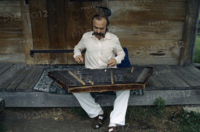 UKRAINE, Kiev, Man playing zither like instrument called a dulcimer.