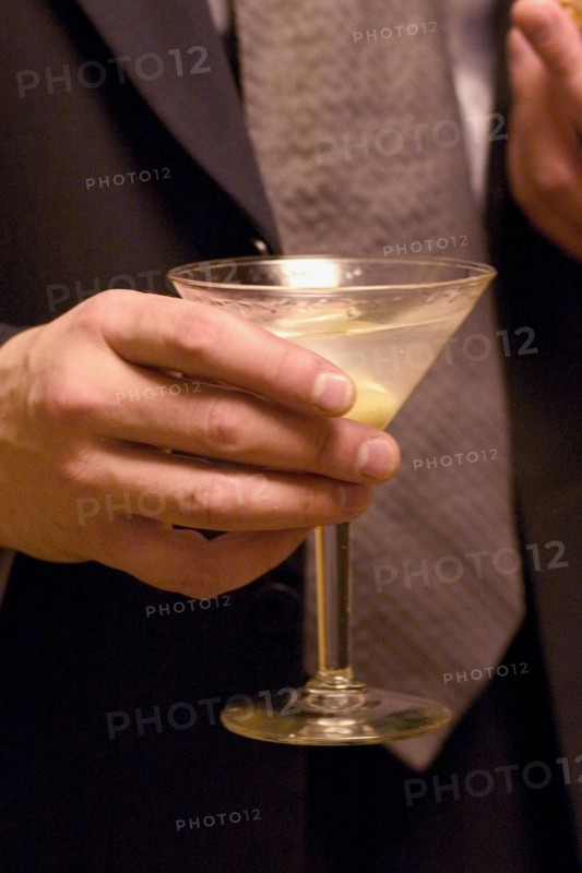 USA, Minnesota, St Paul, Business man holding martini cocktail at social gathering.