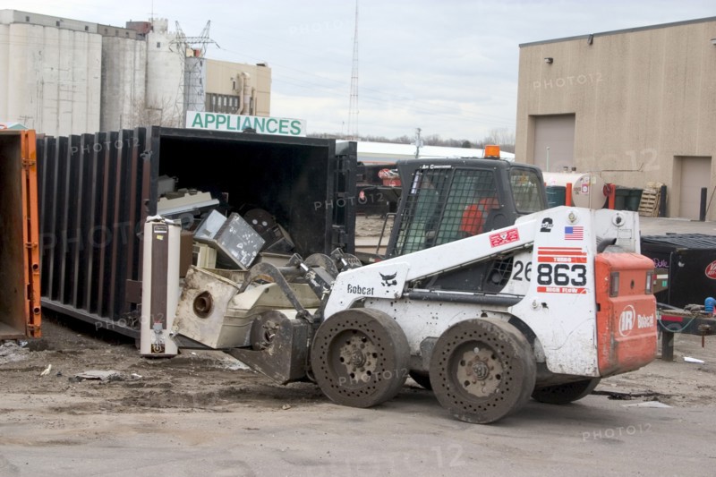USA, Minnesota, St Paul, Bobcat a front end loader removing items from the appliance bin in the Vasko Disposal Solutions junk yard.
