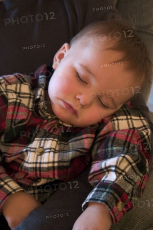 USA, Minnesota, Plymouth, 1 year old grandson sound asleep at the family Christmas party.