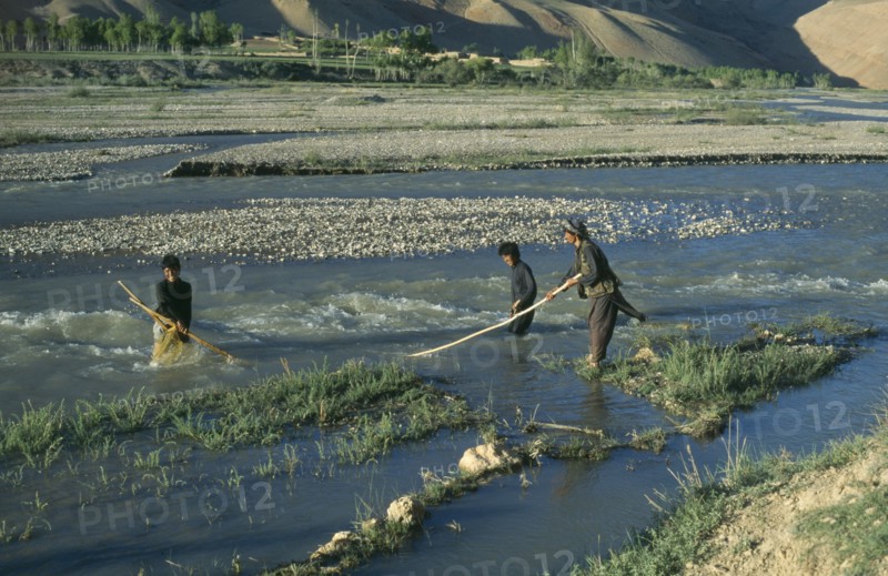 AFGHANISTAN, Bamiyan Province, Yakawlang, Man and boys fishing in river.